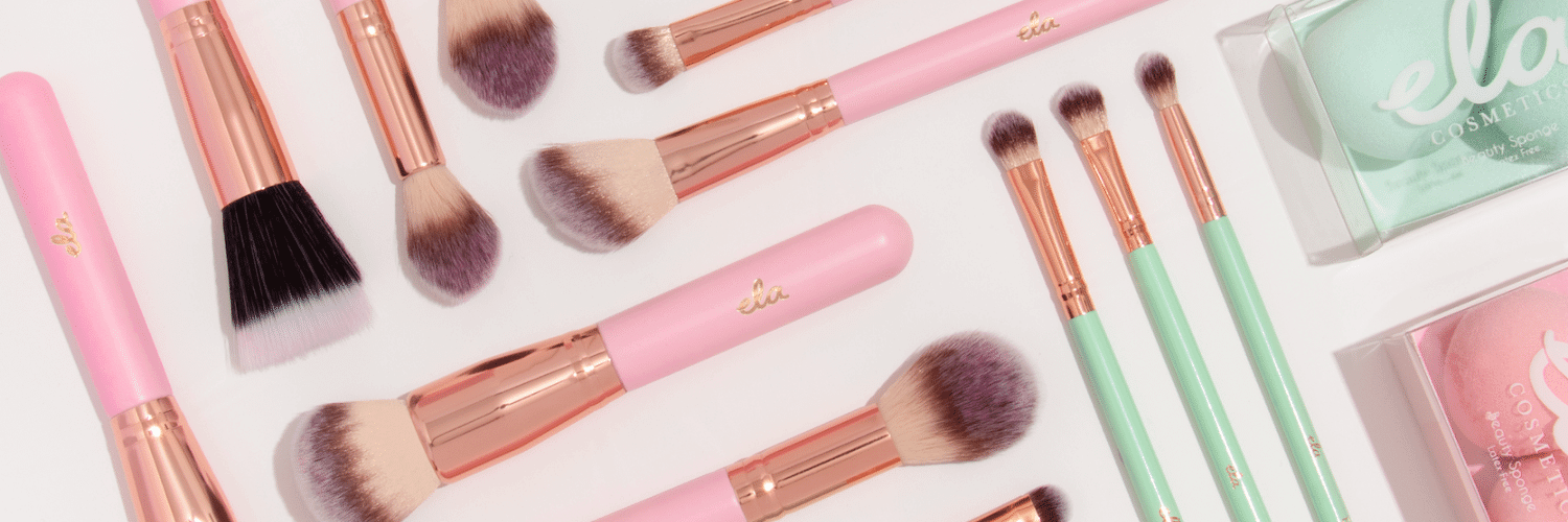 Close up of pink brushes, mint brushes and beauty sponges.