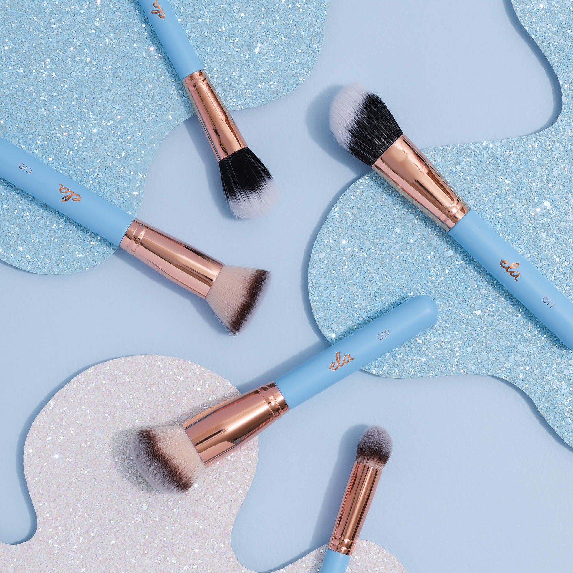 five baby blue brushes on a blue sparkly background